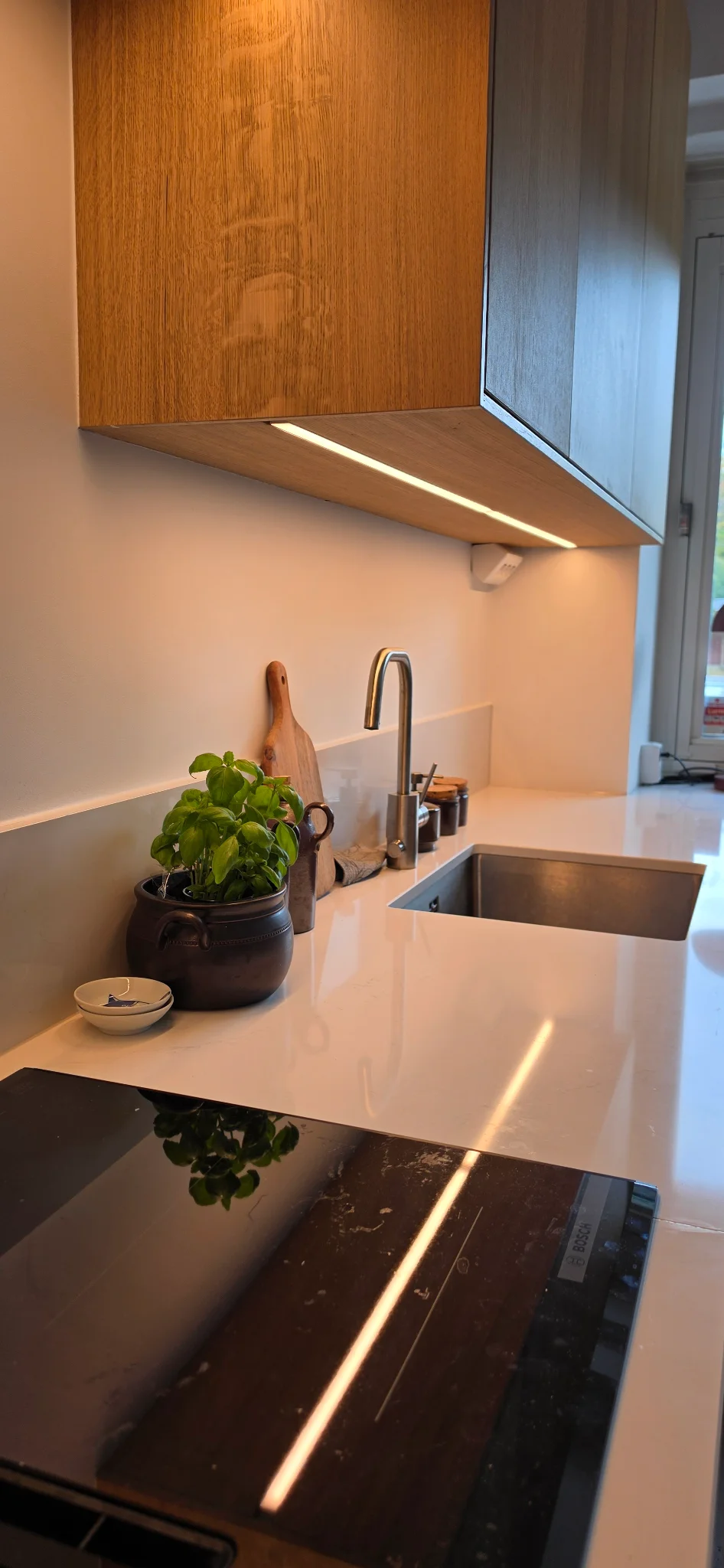 Detalj av bänkskiva, diskho och belysning i det färdiga köket