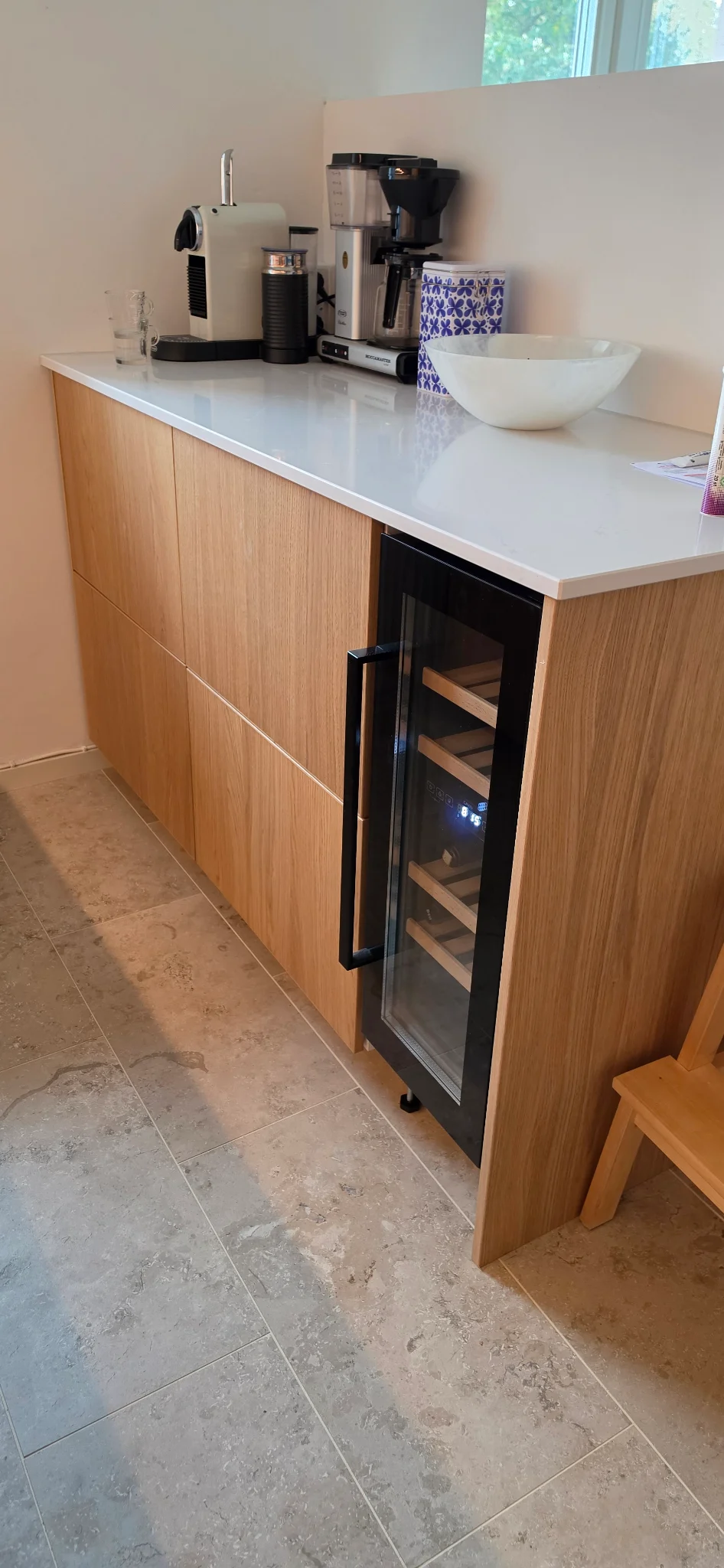 Kaffehörna med skåp och vinkyl i det färdiga köket