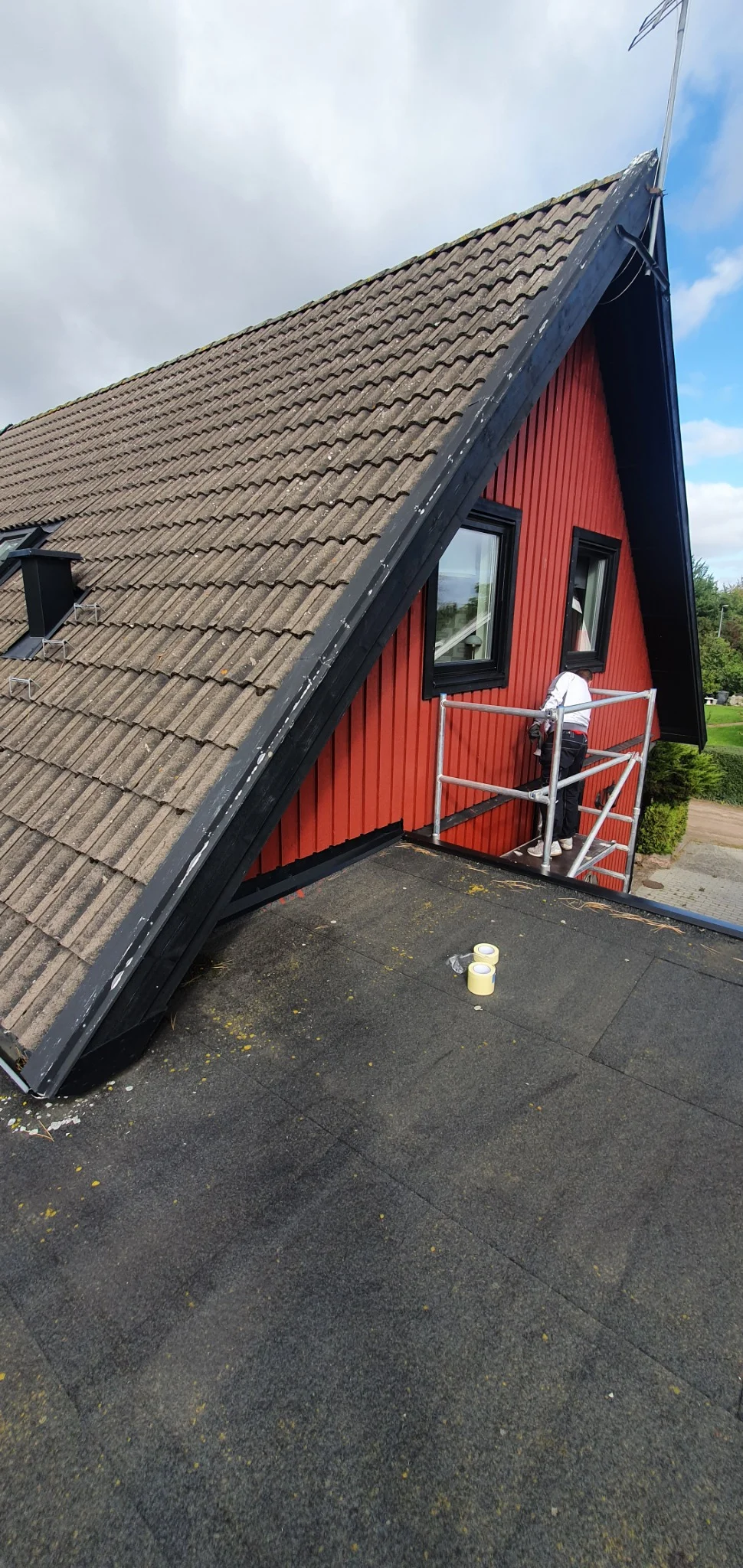 Målning av röd träfasad under fasadarbete i Sunnanå, Burlöv